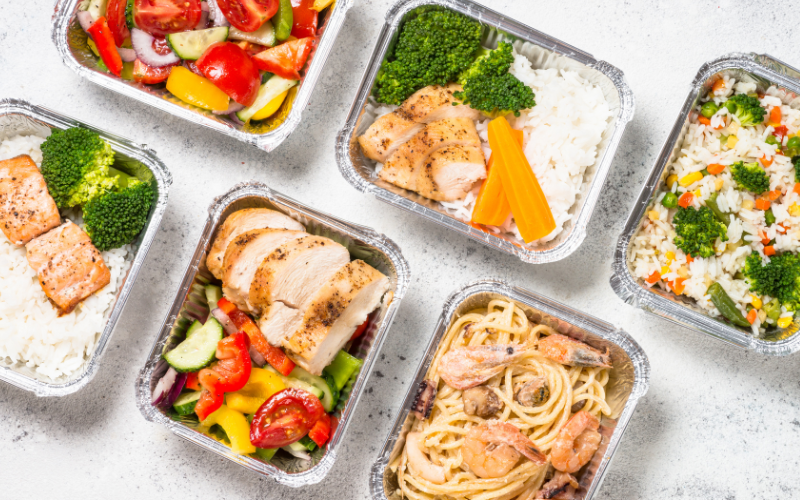Marmitas saudáveis com arroz, legumes coloridos e proteínas como frango e peixe.